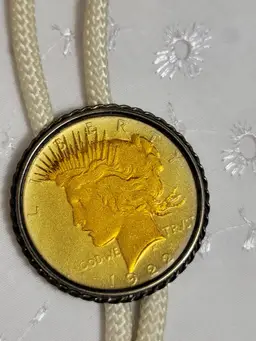 #07 A 1922 Peace dollar gold coin and bolo set with cream cord and gold tips