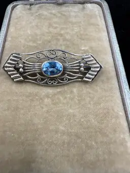 Art Deco sterling silver filigree pin or brooch featuring a blue topaz