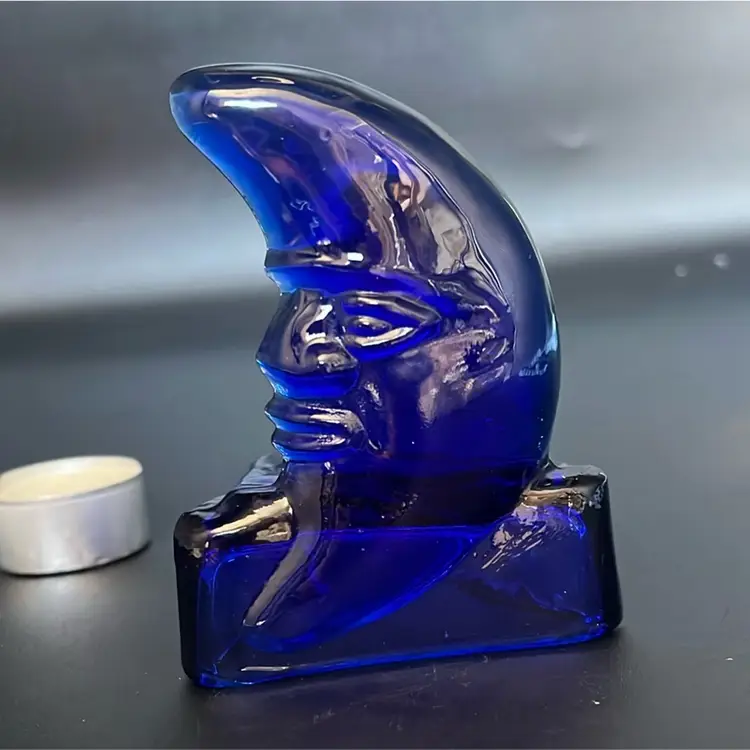 vintage cobalt blue glass celestial candle holder featuring a "man in the moon" face design.