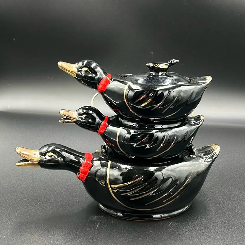 This is a vintage stacked duck tea set. Redware with gold gilding