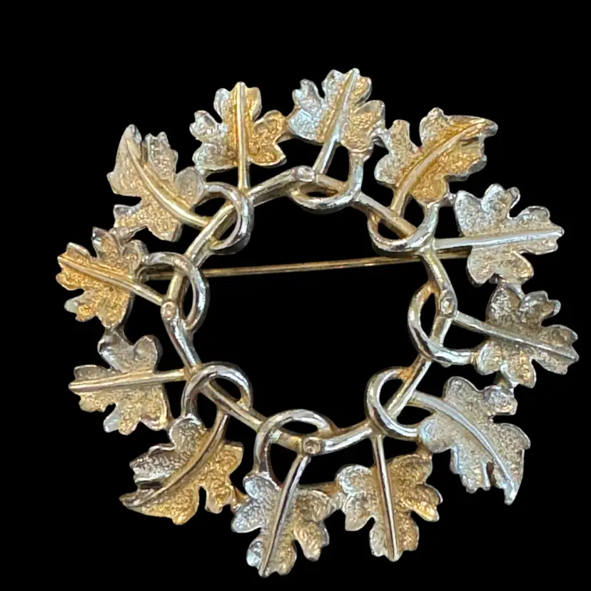 Vintage Sarah Coventry silver and gold-tone maple leaf wreath brooch.
