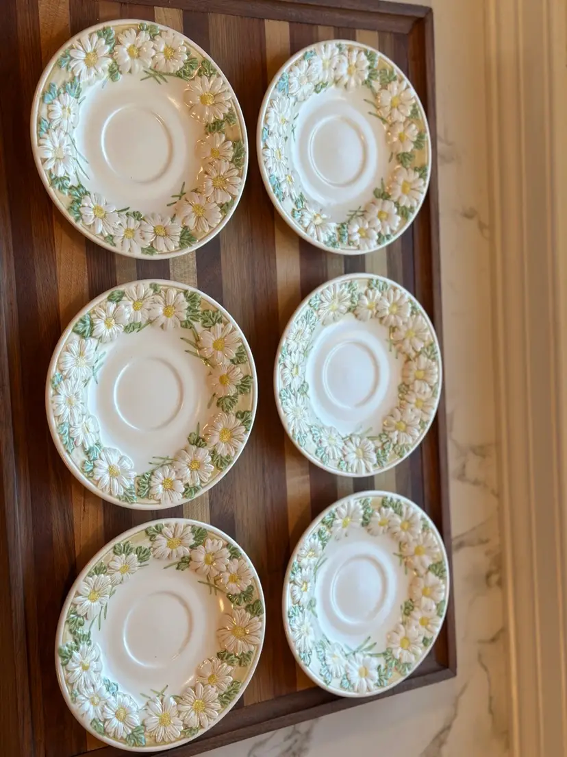 6 Metlox Poppytrail Sculptured Daisy saucers. 
Pattern: Sculptured Daisy, featuring embossed white daisies with yellow centers and green leaves.  Discontinued pattern, manufactured between 1964 and 1983. Excellent condition!
Perfect for a Spring table!