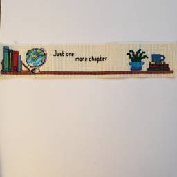 New Cross-stitched bookmark "Just One More Chapter"  on ivory Aida cloth.