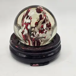 Clear Glass Paperweight with red white slayer on wooden stand