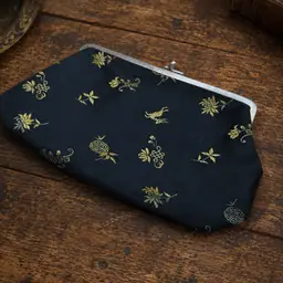 black and gold embroidered silk evening clutch bag with a metal kiss-lock clasp