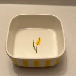 Yellow striped small trinket dish with small flower. It is in excellent condition.