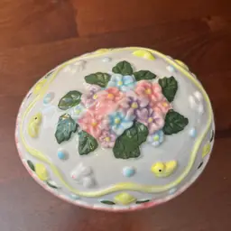 A vintage ceramic Easter egg lidded box with floral and animal motifs.5.5”