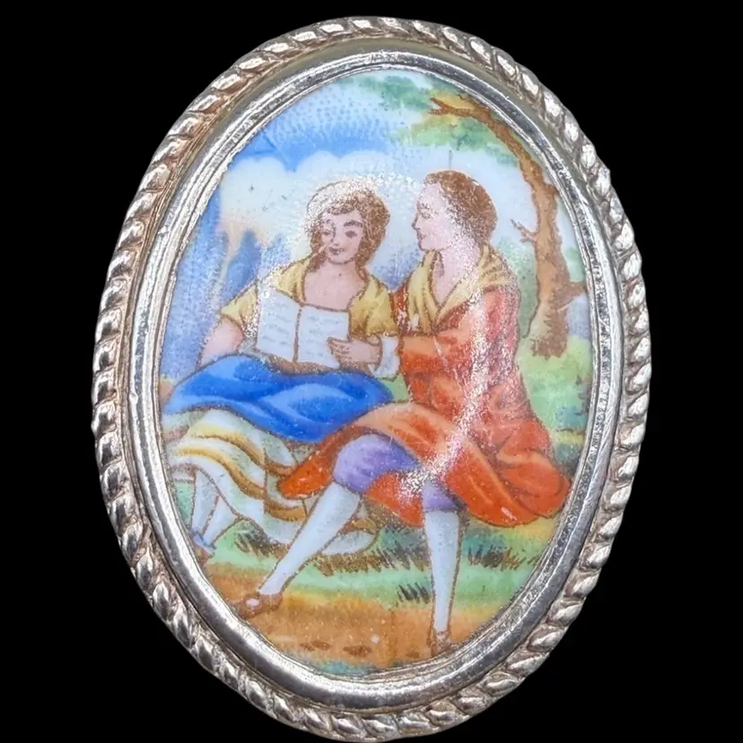 vintage hand-painted porcelain Limoge France courtship scene brooch with a twisted metal frame.