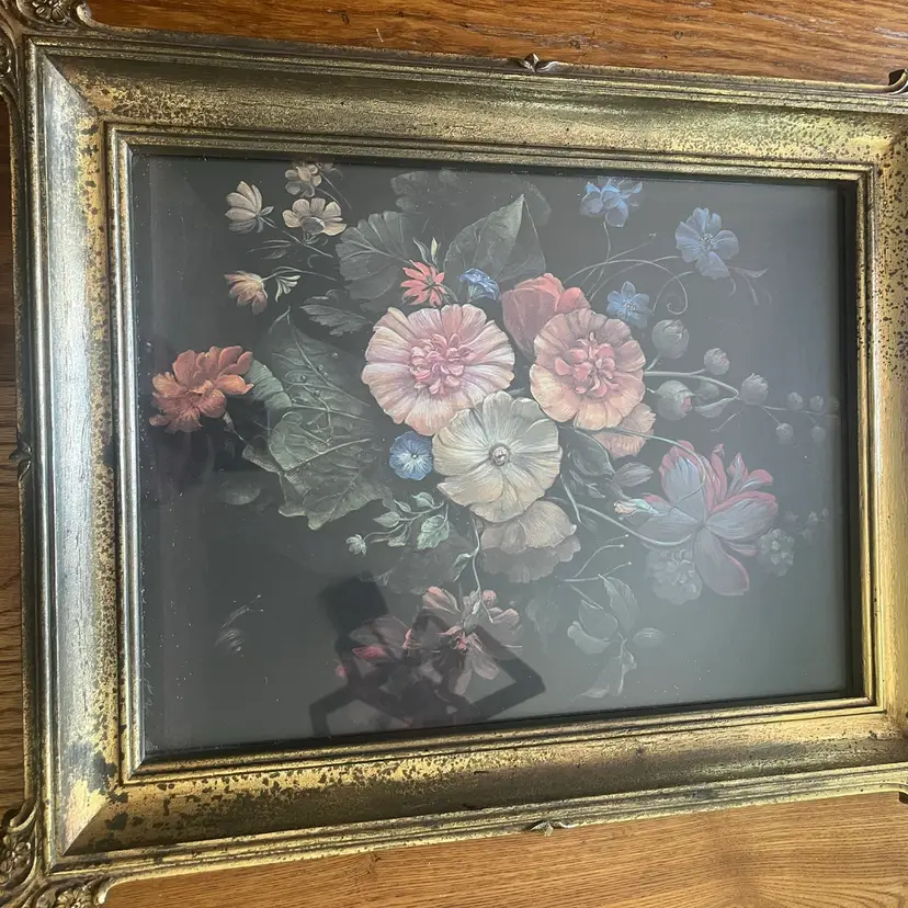 A framed print of a floral still life in an ornate Plastic  gilded frame. 19x15