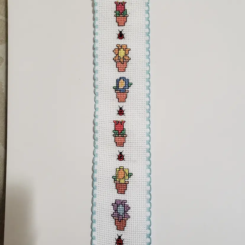New Cross-stitched bookmark with potted flowers and lady bugs on Ribband trimmed with blue