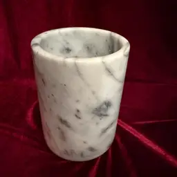 Vintage white marble wine cooler, also frequently marketed as a utensil or pen holder due to its versatile design. 
It is handcrafted and polished from genuine natural marble. 
The item is food-safe and water-tight. 
It can be used to keep wine or champagne bottles chilled for an extended period. 
It also serves as an elegant desk organizer or kitchen utensil holder.