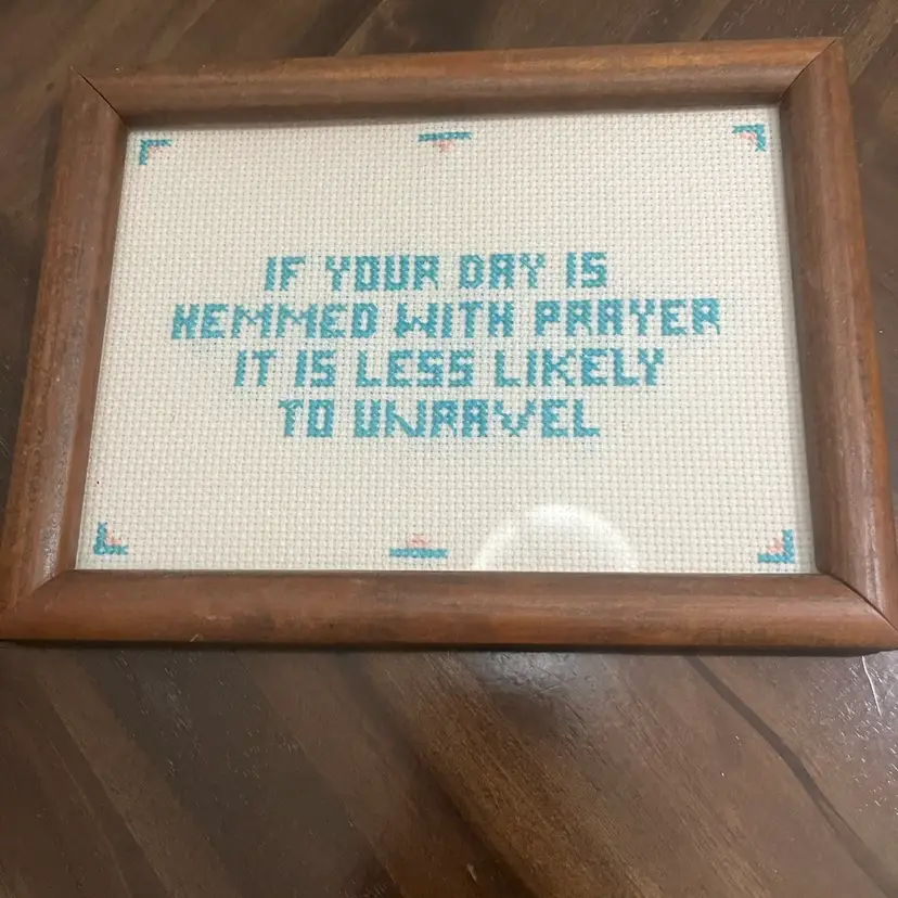 Framed cross-stitch with a religious quote about prayer.