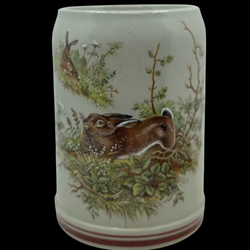 Beer stein featuring a detailed painted scene of rabbits.