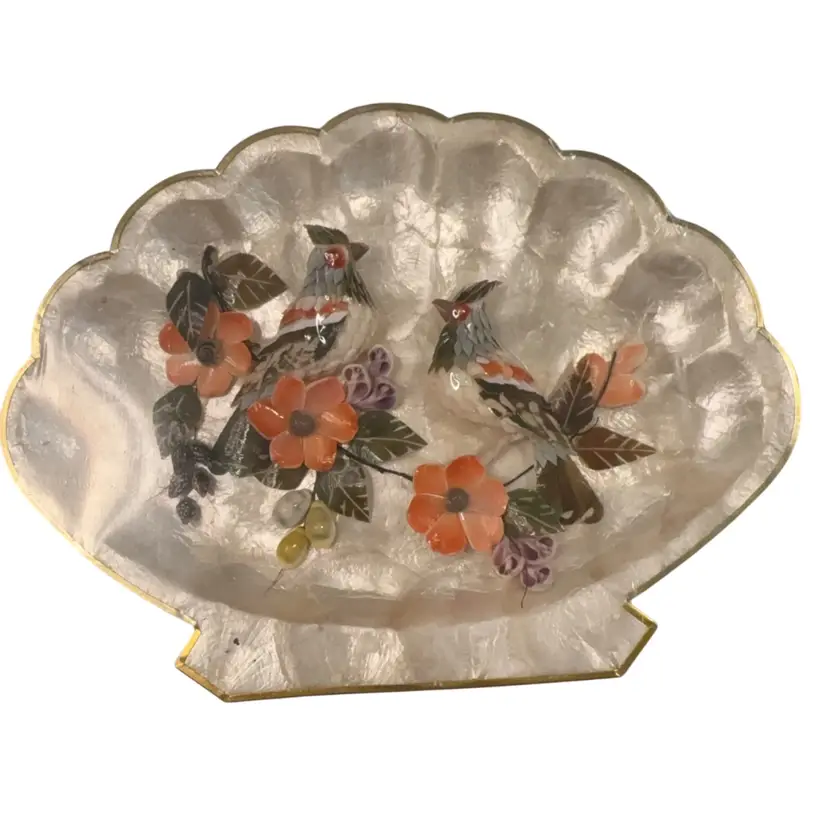 Vintage shell artwork features a pair of Birds and flowers constructed from real shells.The decorative piece is crafted on a Capiz shell base and trimmed with a brass-edged scalloped frame. 12.5” X 9.5” Hanger On Back No Breakage