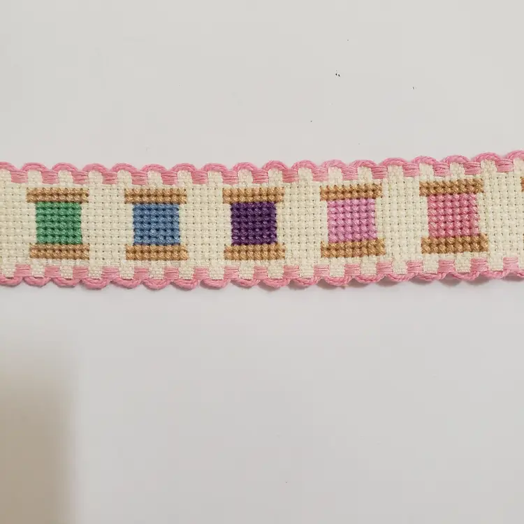 New Cross-stitched multi colored spools of thread themed Ribband ivory with pink trim.