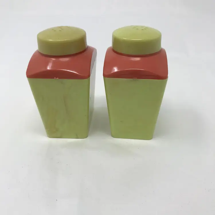 Aladdin USA MCM plastic salt and pepper shakers. Bright green and terra cotta red with gold colored details. No chips or cracks. Beautiful Deco style writing on the caps. 3 H x 2 L x 1.2 W.