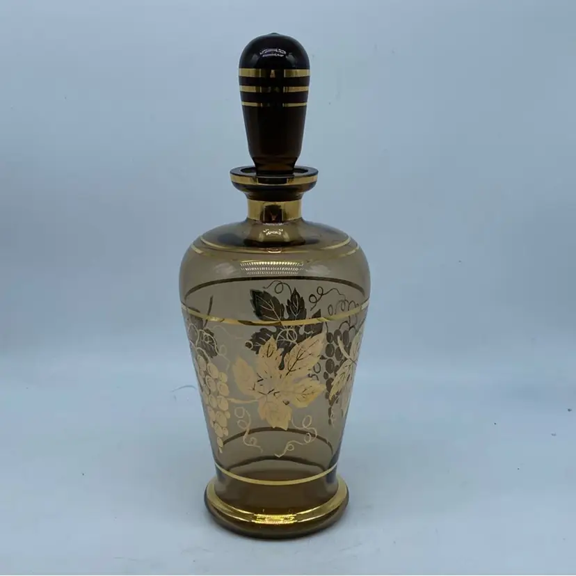 #1331 Mid-20th century smoky glass decanter with gold grapevine decoration.