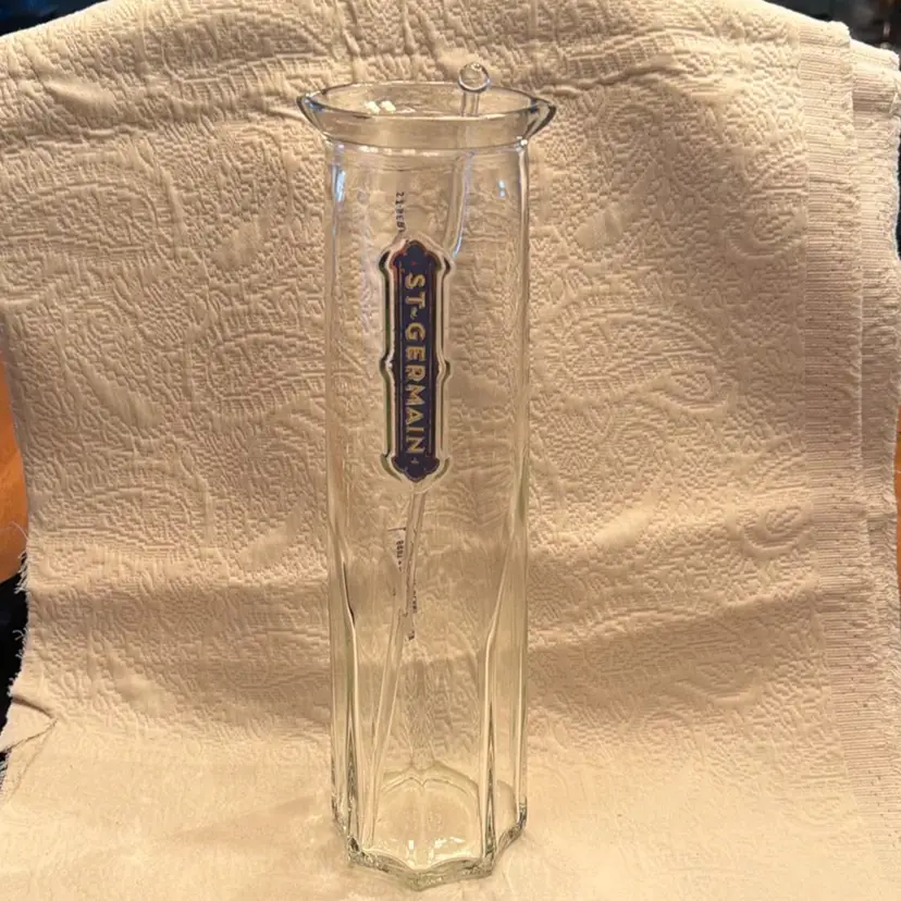 St. Germain Elderflower Liqueur glass carafe, specifically designed as a mixing pitcher for cocktails. Features a clear, Art Deco-inspired octagonal shape with the prominent blue and gold St-Germain logo.