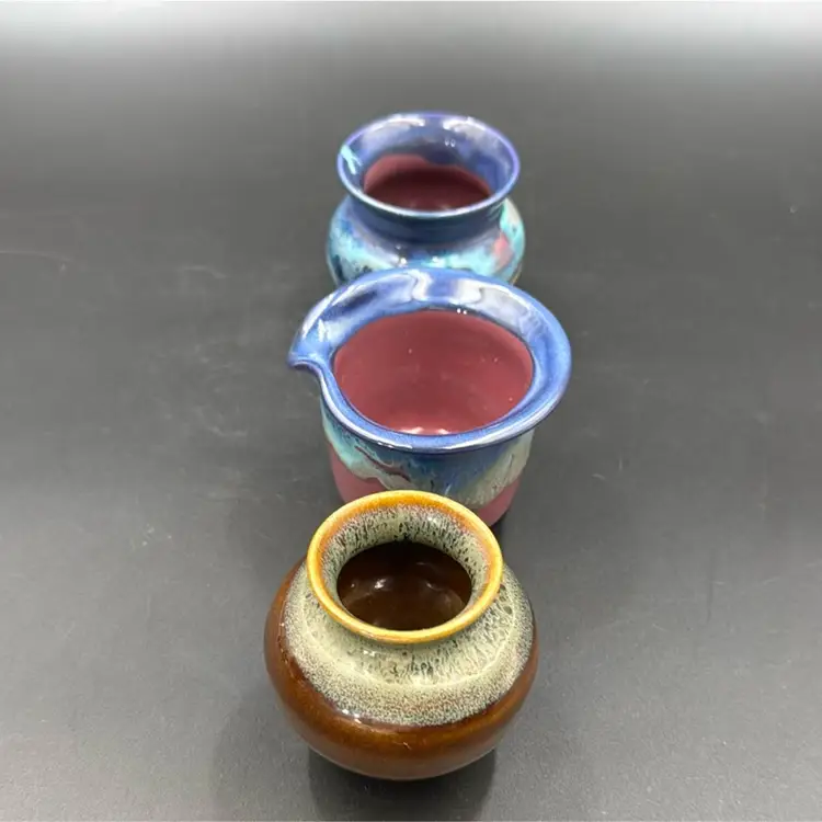 A set of three pottery dishes, too many vases and one creamer