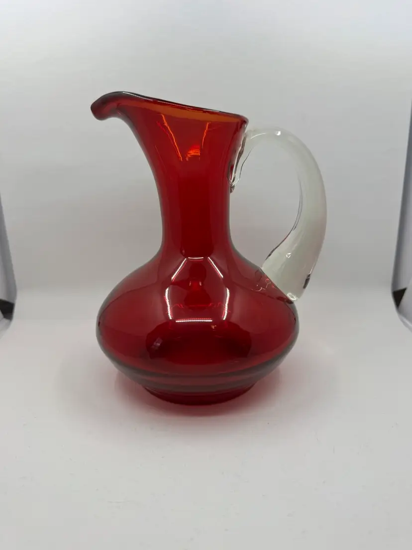 Vintage ruby red hand-blown glass pitcher with clear applied handle.