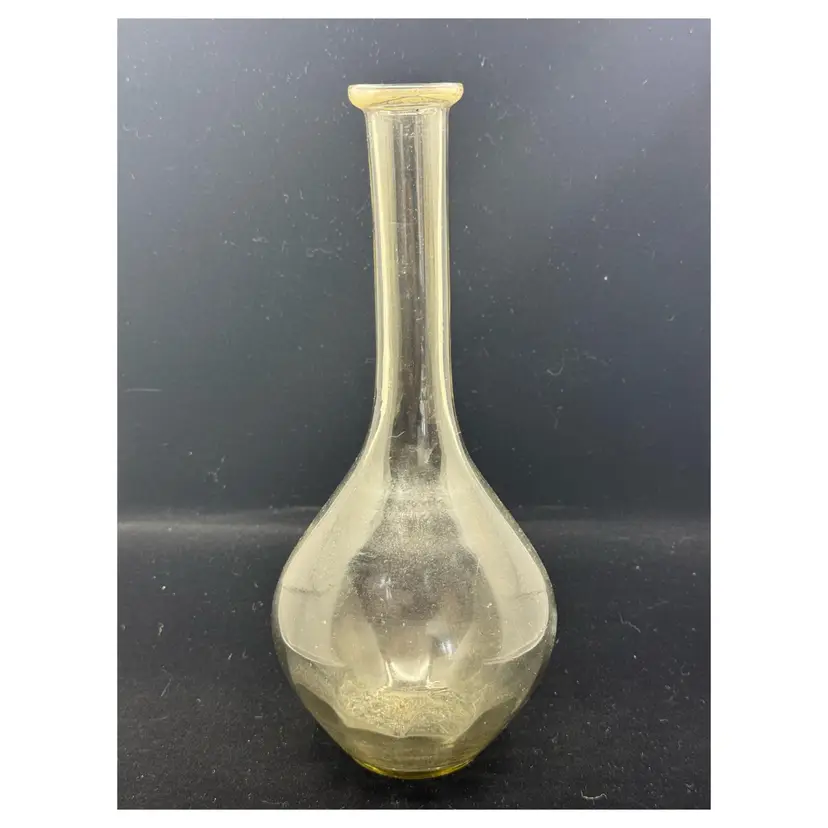 A vintage clear glass bottle with a narrow neck, Has A Slight Smoky Hue