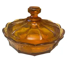 This is a vintage Fostoria Amber Coin Glass covered candy dish. It is part of the Fostoria Coin Glass collection, which was produced from 1958 to 1982