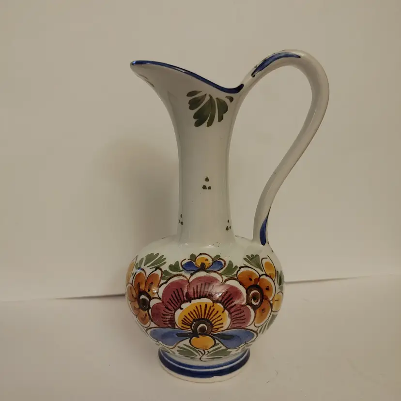 Delfts Holland floral pitcher. 6.75 inches high. 1 small chip on the bottom..
