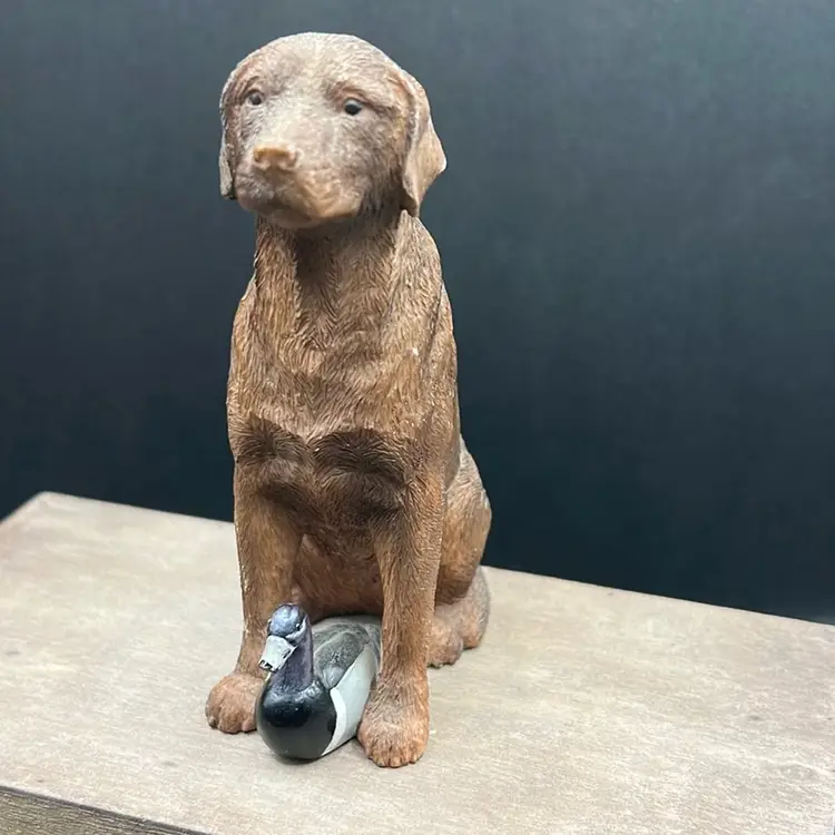 The item in the image is a Sandicast Chocolate Labrador Retriever sculpture, designed by artist Sandra Brie.