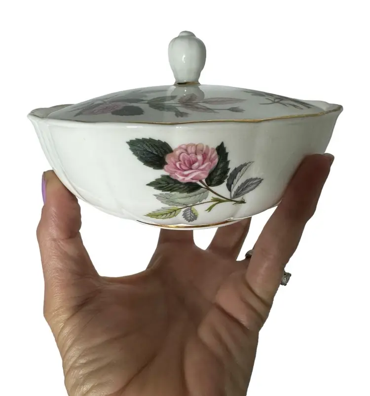 Lovely vintage Wedgwood Hathaway Rose bone china covered /lidded candy bowl/trinket dish. Lightly scalloped edges with gold trim (some wear to gold) and a simple rose  floral pattern. Beautiful condition no cracks or
chips. Minor discoration from age other inside. see all photos 

5.5 diameter approximately 3” tall