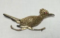 Roadrunner brooch, gold tone, red rhinestone eye, textured 2.25"