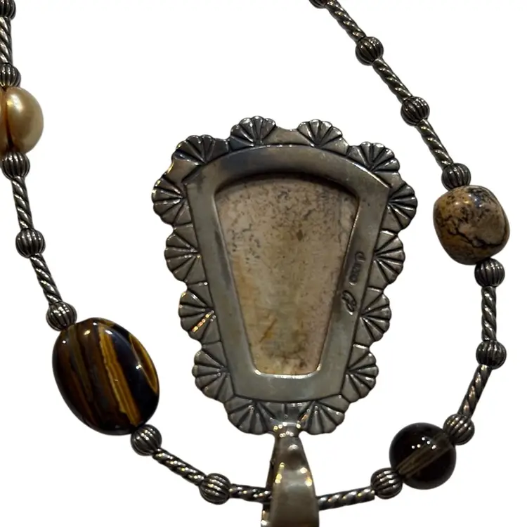 This is a Carolyn Pollack Relios 925 sterling silver station necklace featuring tiger's eye, jasper, smoky quartz, and pearl beads with a removable enhancer pendant.  17” Drop To Pendant.