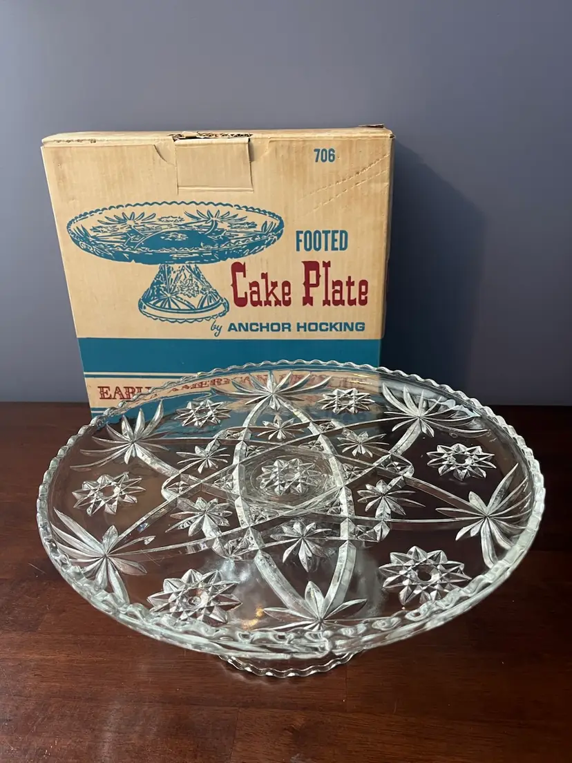 Anchor Hocking clear glass footed cake plate with Prescut pattern.
13.5 Inches Diameter, When Tray On Base It Is 5.5 “