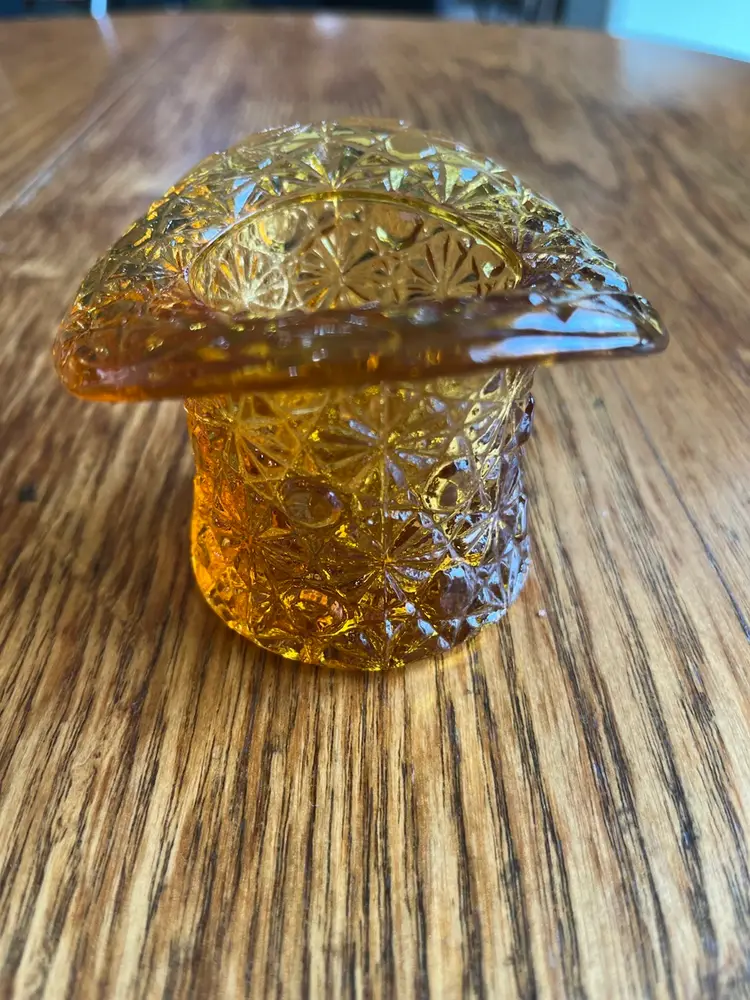 Vintage amber glass top hat toothpick holder with pressed glass pattern.