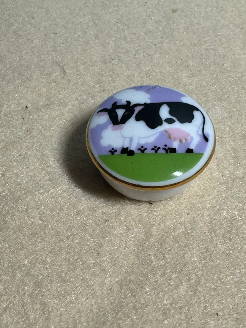 Porcelain Trinket box featuring a Grazing Holstein Cow-chip On Edge Of Lid