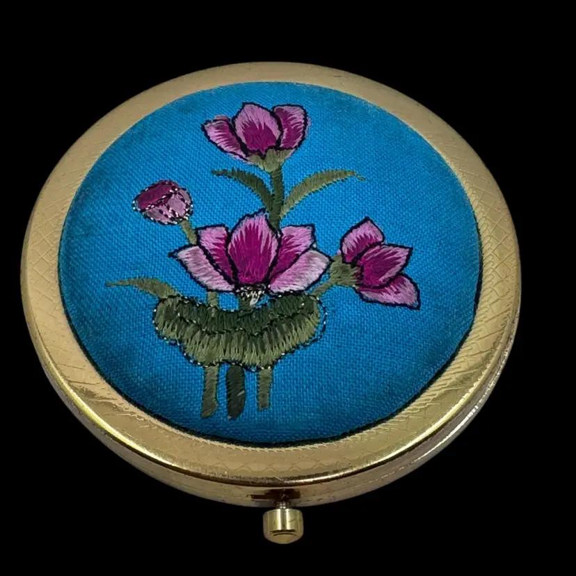 Vintage embroidered floral compact mirror with gold-toned metal casing.