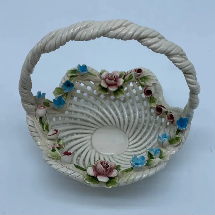 #4211 A signed Italian Capodimonte porcelain basket with applied floral motifs and a woven handle.