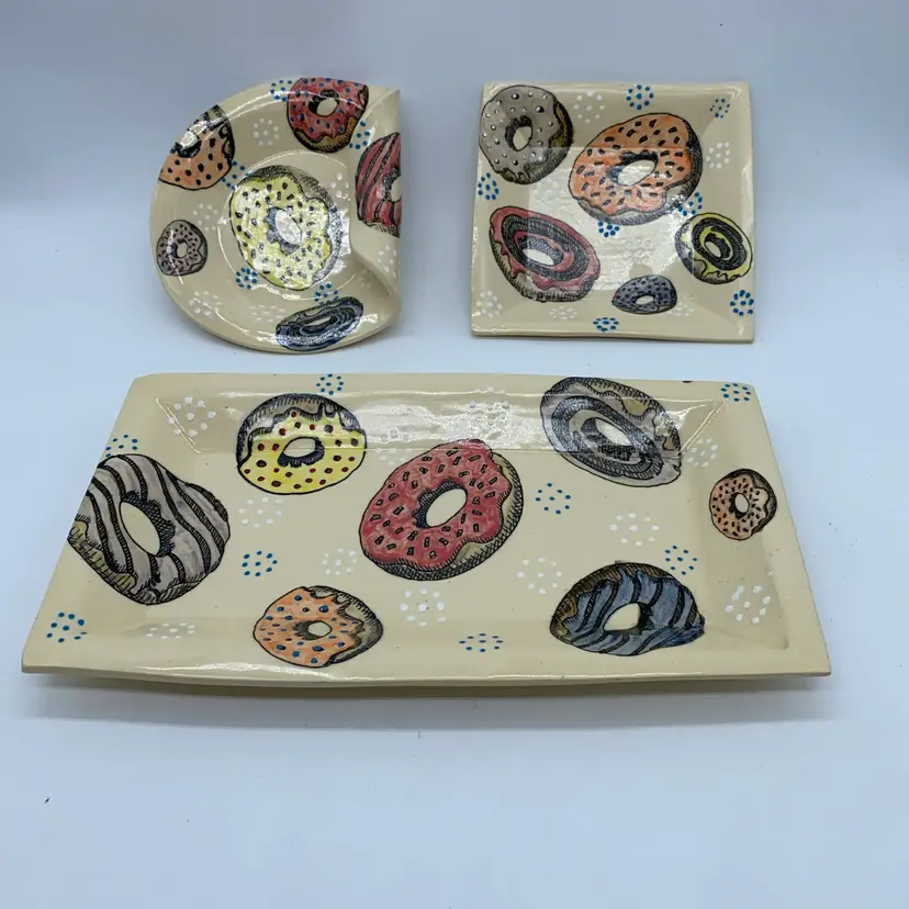 #2204 Doughnut Set of three hand-painted Hand Made ceramic dishes with doughnut motif and braided base, signed YC.