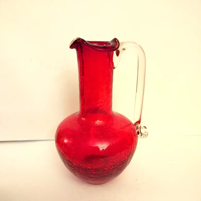 Ruby red hand blown crackle glass pitcher. Has pontil mark. 5 inches high. No chips or cracks.