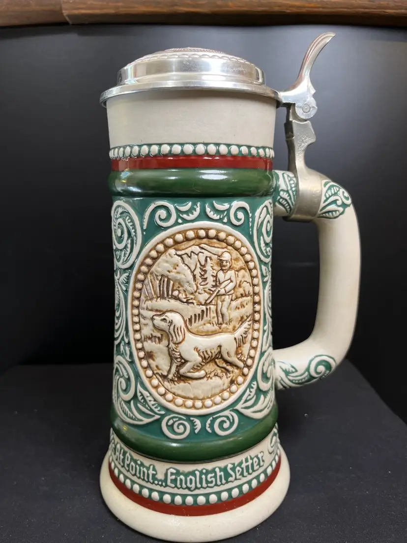 Beer Stein Handcrafted in Brazil Exclusively for Avon-1978. Metal Silver Tone Lid. One Side Features "At Point...English Setter" & Scene. The other side, "The Strike..Rainbow Trout"