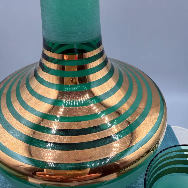 Mid-Century Modern "genie" style decanter with a tapered neck and matching bulbous stopper, paired with four matching cordial or shot glasses.
 10x4”