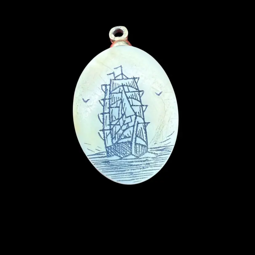 vintage scrimshaw pendant featuring a sailing ship motif