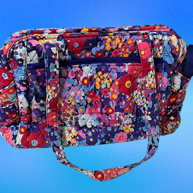 This is a Vera Bradley Stroll Around Baby Bag Or is a large tote bag with a colorful floral pattern. The bag features a laminated, easy-clean interior liner and multiple pockets for organization. Exterior features include two slip pockets, a zip pocket, and a front compartment containing a removable changing pad. It includes a 15" strap drop and removable 12" stroller straps to attach to a stroller handle. 17” Wide  By 11” Tall Excellent Condition
