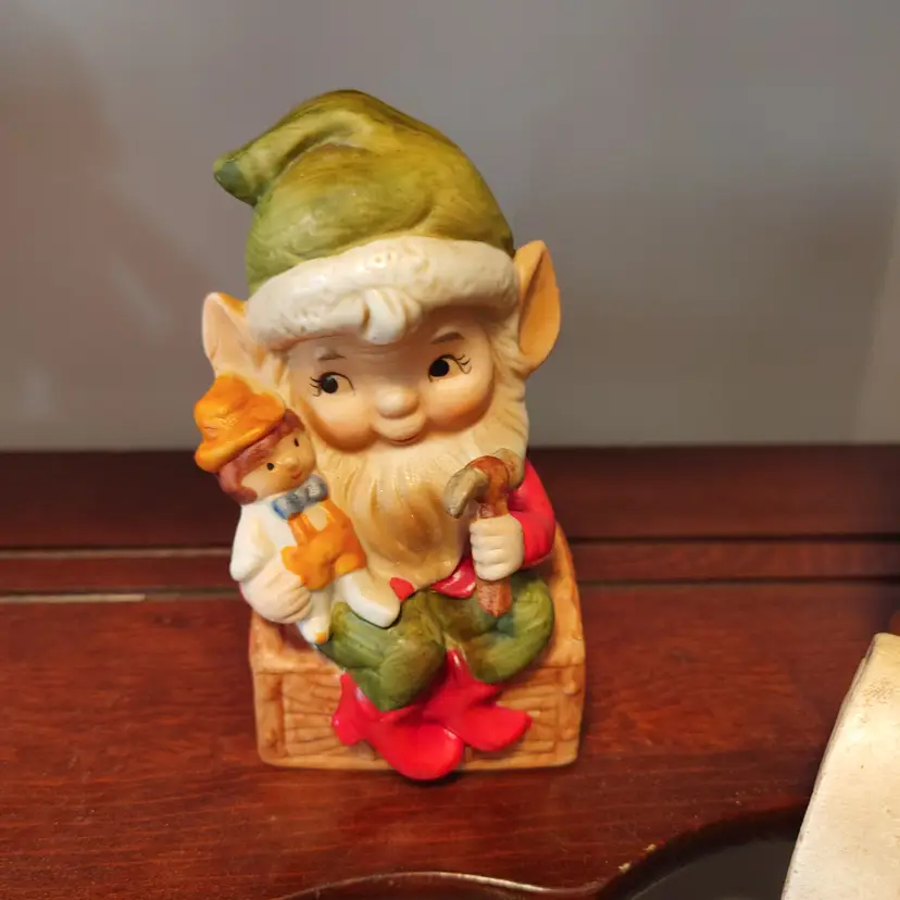 Elf with hammer and doll. Figurine.