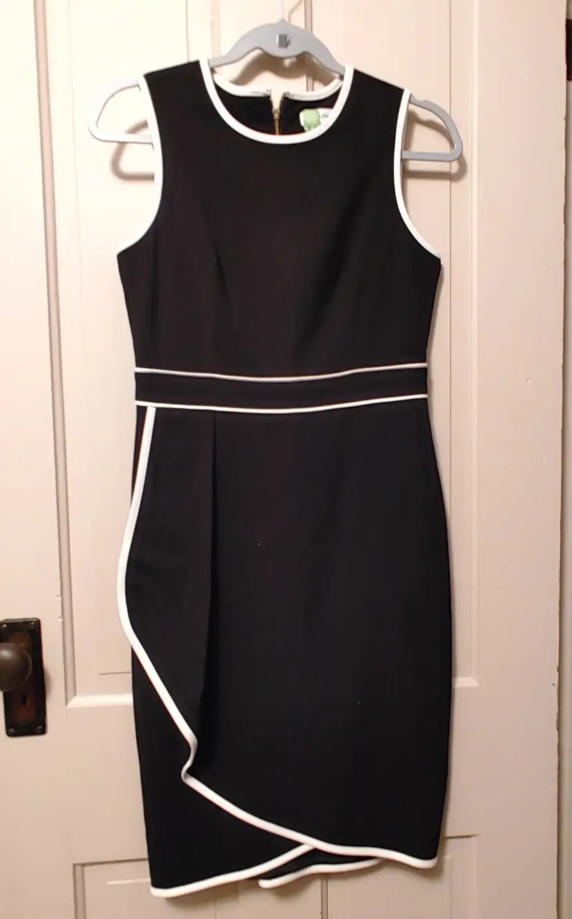 Dress- Brand: Calvin Klein. Size 4. Black dress with white trim. Material: 63% polyester, 33% rayon, 4% spandex. No callouts.