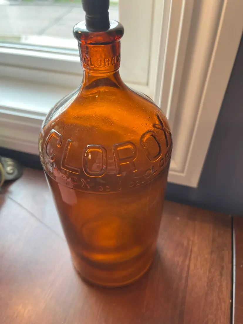 Antique amber glass Clorox bleach bottle with embossed lettering and Rubber stopper. 10”  Circa 1930s