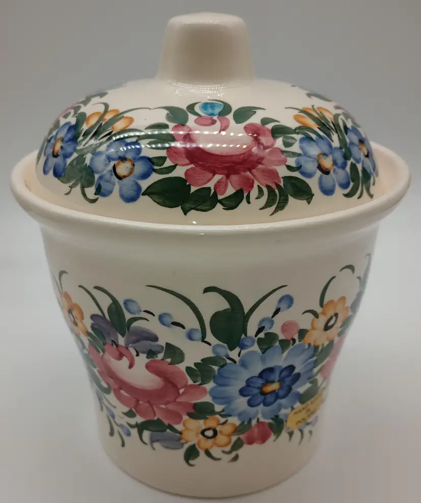 Floral ,Hand painted Pottery Canister, Made In Poland , Sticker On Side.
This Beauty Measures Approximately 7.5 Inches Tall By 6.25 Inches Wide. No Chips Or Cracks.