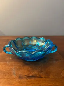 Vintage blue pressed glass candy dish with scalloped rim and handles.  5” Diameter from handle to handle it 7 inches.