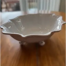 A white, three-footed ceramic bowl with "Made in Portugal" marking. 11” x 12”