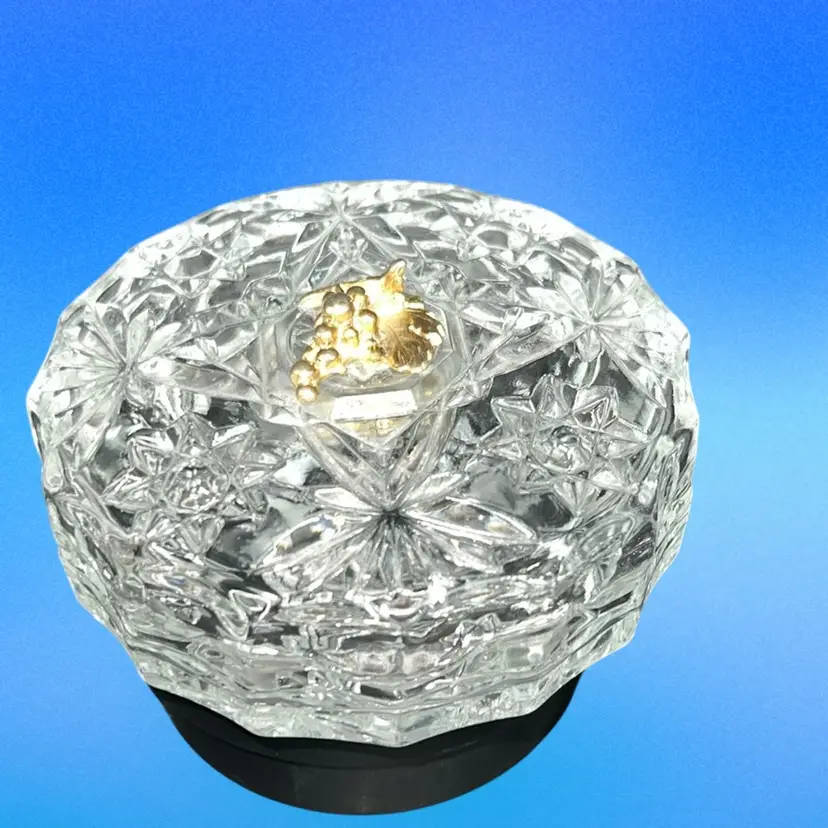 This is a vintage Italian cut glass trinket dish with a brass grape embellishment.