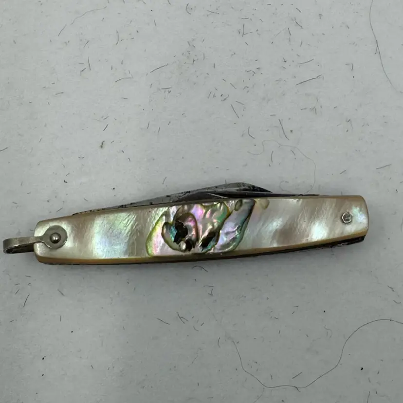Vintage folding knife with mother-of-pearl or abalone inlay and a silver-tone finish, 2”